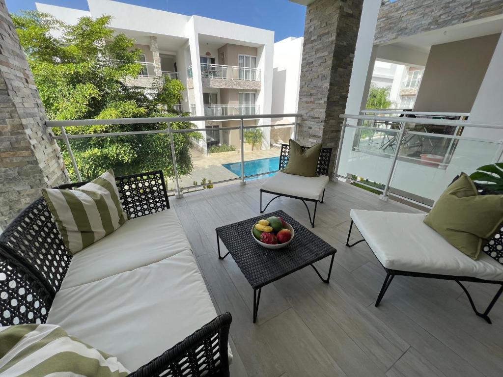 een patio met een bank en een fruitschaal op een tafel bij Casa Mulata Paseo del Mar Pool & Playa in Punta Cana