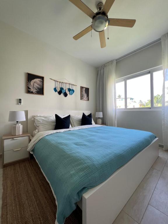 a bedroom with a large bed with a ceiling fan at Casa Mulata Paseo del Mar Pool & Playa in Punta Cana