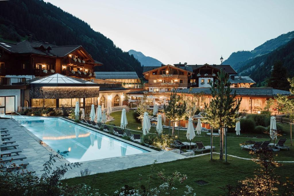 um hotel com piscina em frente a um edifício em Familien Natur Resort Moar Gut em Grossarl