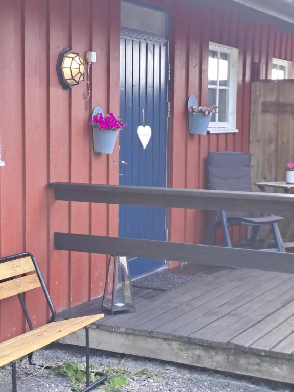 a bench in front of a house with a blue door at Klockestrandstugan-Höga kusten in Kramfors
