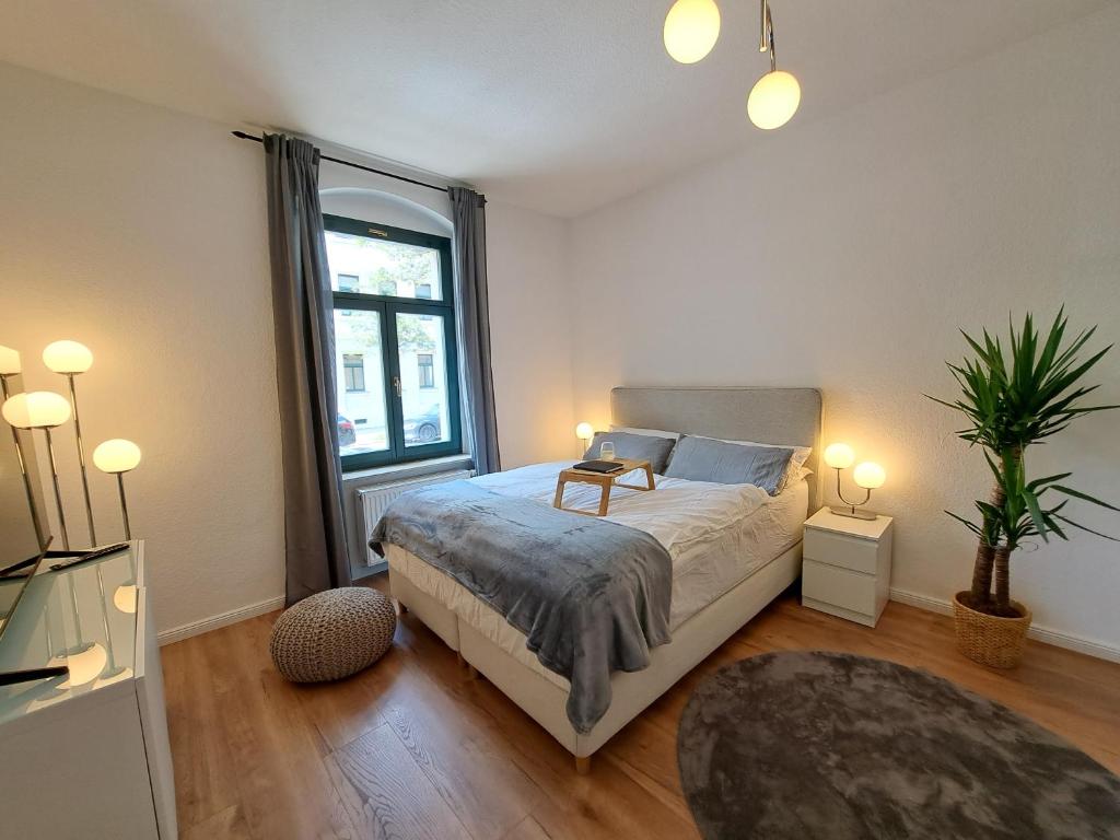 een slaapkamer met een bed en een groot raam bij Gemütliche helle Ferienwohnung in Dresden
