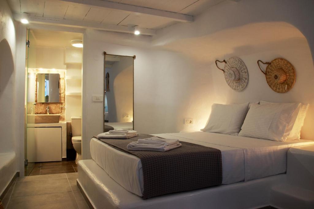Habitación blanca con cama y baño. en il Marinero mandrakia, en Mandrakia