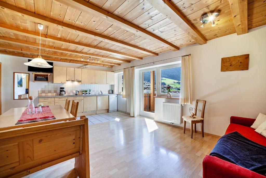 una cucina e un soggiorno con divano rosso e tavolo di Mühlanderhof Apt Piz Lad a Resia