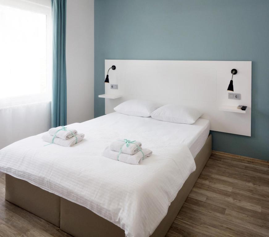 1 dormitorio con 1 cama blanca grande y 2 almohadas en Alicante Hotel - Adult Only, en Bozcaada