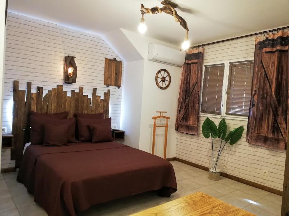 1 dormitorio con 1 cama con cabecero de madera en Studio 19 cosy avec jacuzzi et jardinet privatifs, en Draguignan