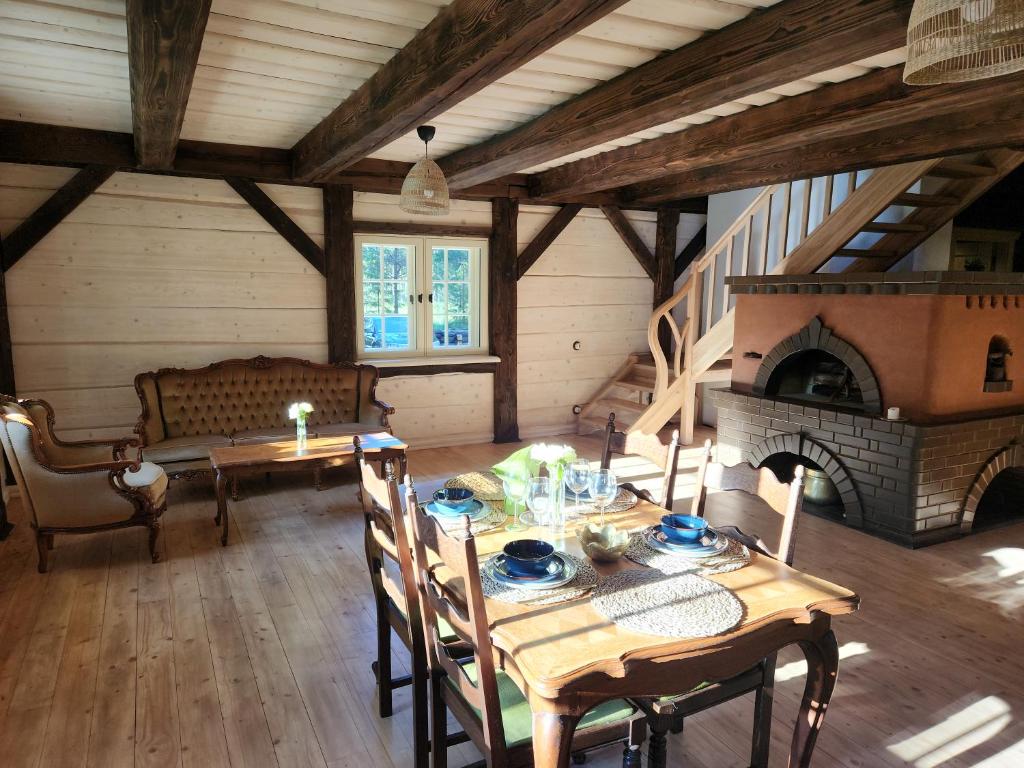 a dining room with a table and a fireplace at Atpūtas parks Priežvanagi in Livža