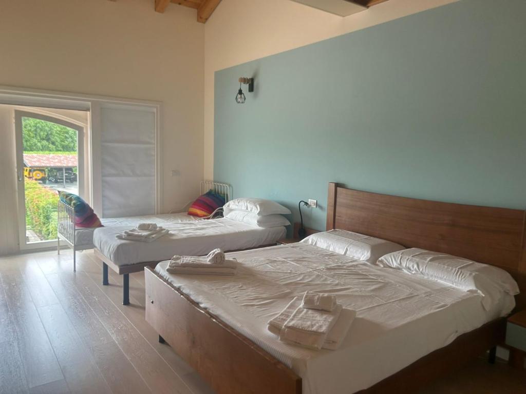 1 dormitorio con 2 camas, silla y ventana en Ranch borgo bella vita, 