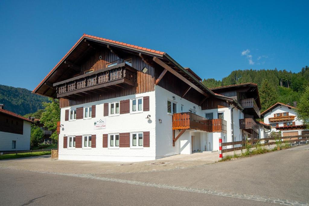 a large white building with a wooden roof at Ferienwohnung Immerschön in Pfronten