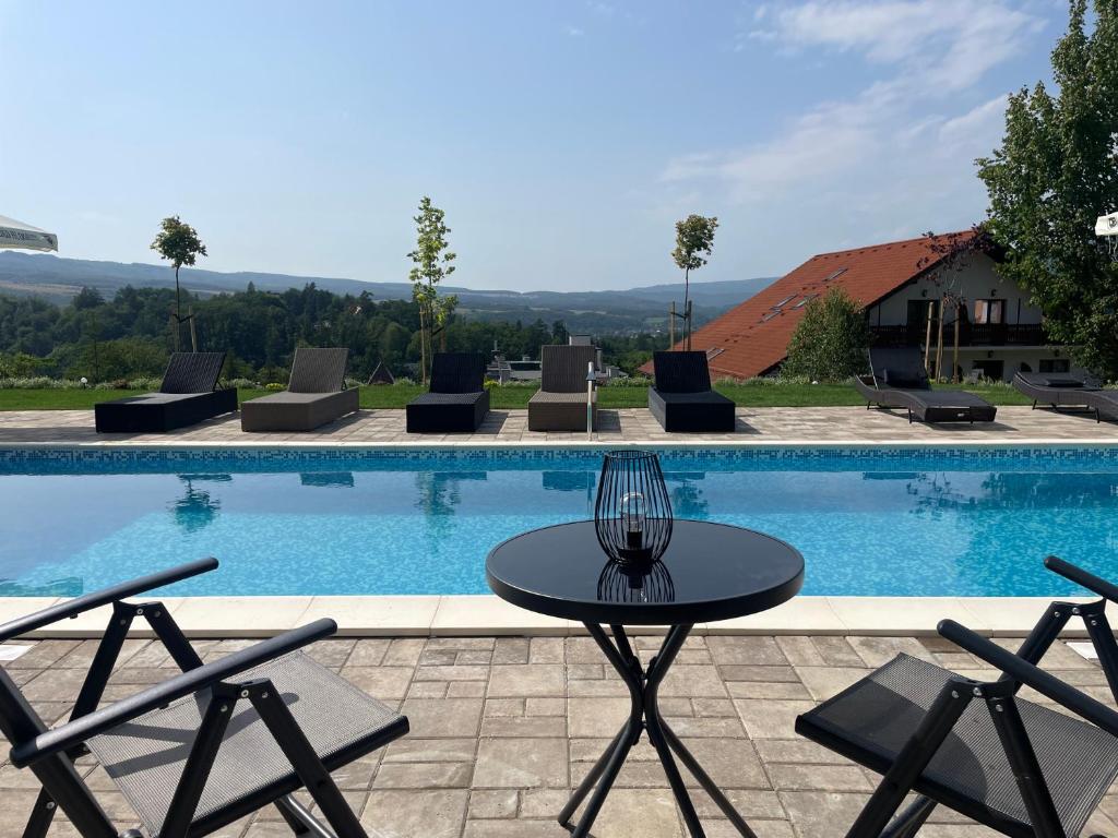 a table and chairs in front of a swimming pool at Hotel Relax Sovata in Sovata