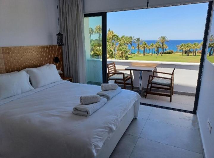a bedroom with a large bed with a view of the ocean at Terrazza Suites in Paphos City