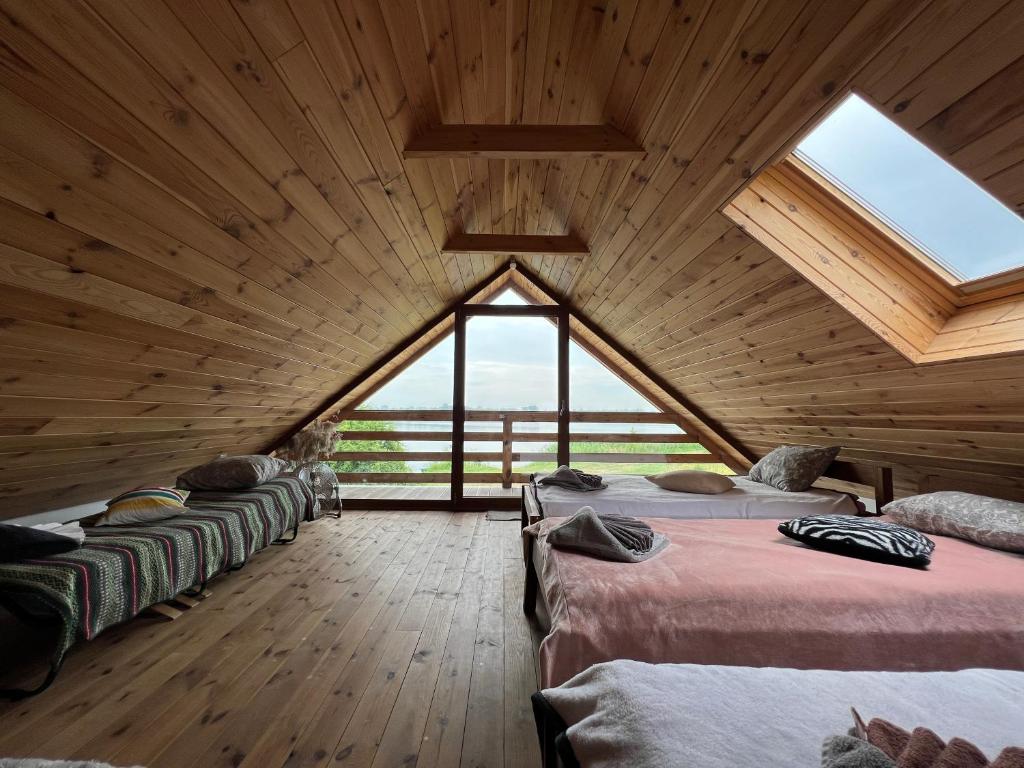 a room with three beds in a room with a large window at Osmolicka Chatka in Ryki