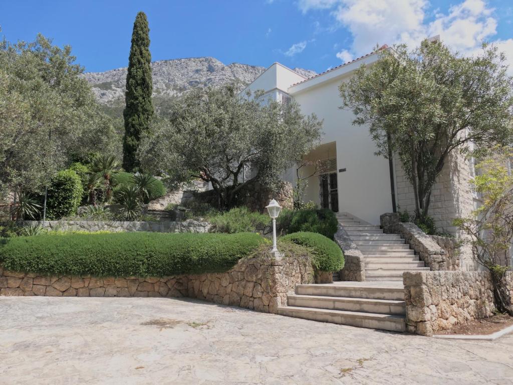 a house with stairs and trees in front of it at Villa Marina in Brela