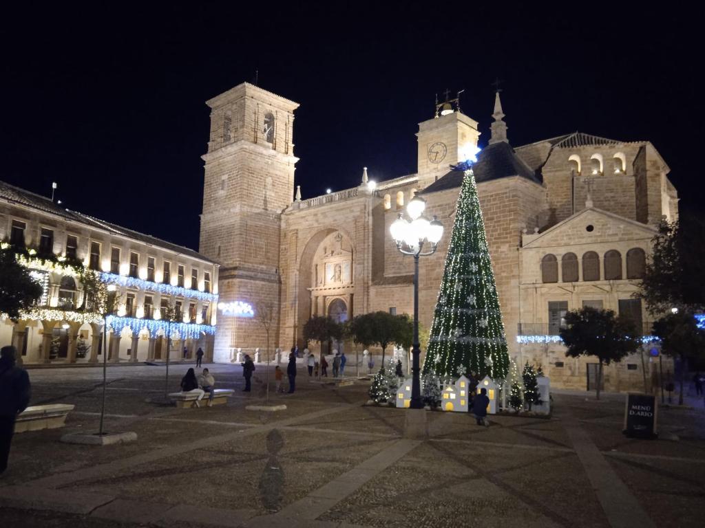 Un árbol de Navidad delante de un edificio por la noche en Señorio de Quevedo en Villanueva de los Infantes