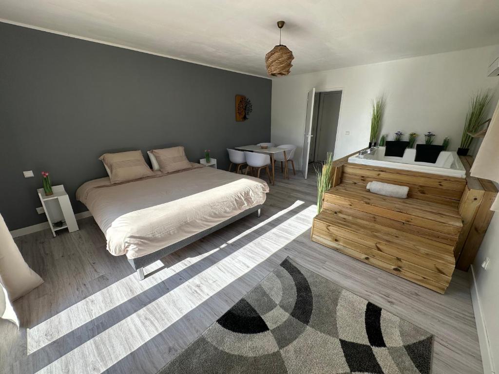 sypialnia z dużym łóżkiem i stołem w obiekcie Studio SPA Balnéo - Jardin privé w mieście Maureilhan-et-Raméjan