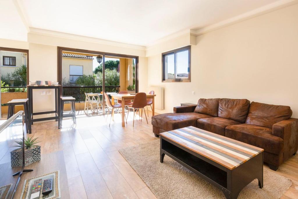 een woonkamer met een bank en een tafel bij Beautiful furnished apartment in a private Residence with Pool in Cannes