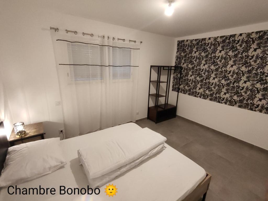 ein Schlafzimmer mit einem weißen Bett und einem Fenster in der Unterkunft La Villa Yucca Vias Plage - 300m plage et centre in Vias