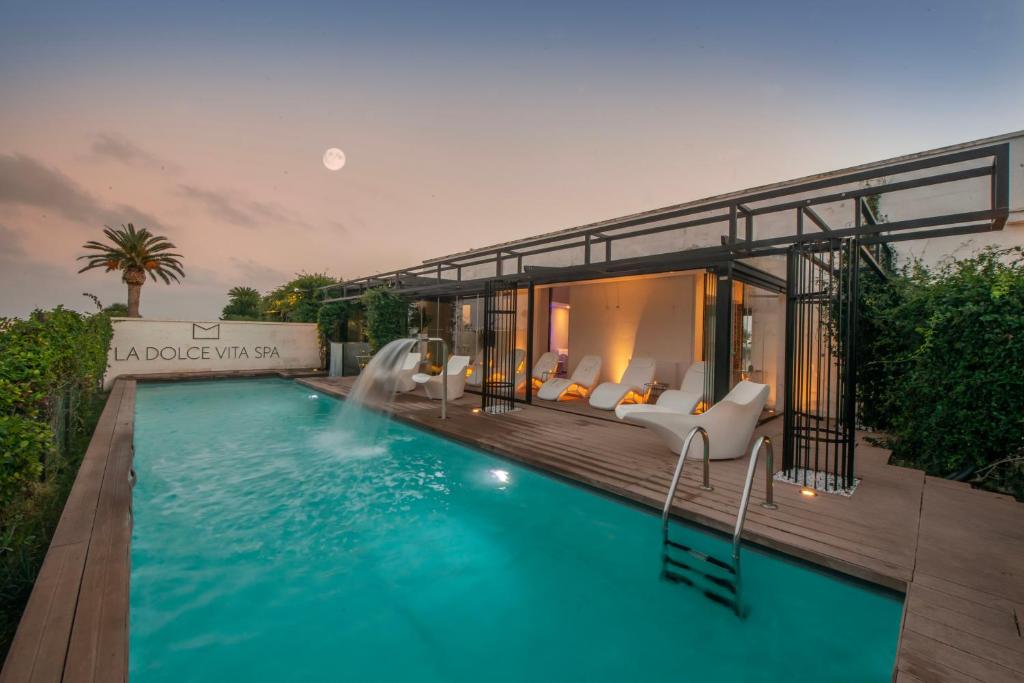 a villa with a swimming pool and a house at Grand Hotel Masseria Santa Lucia in Ostuni
