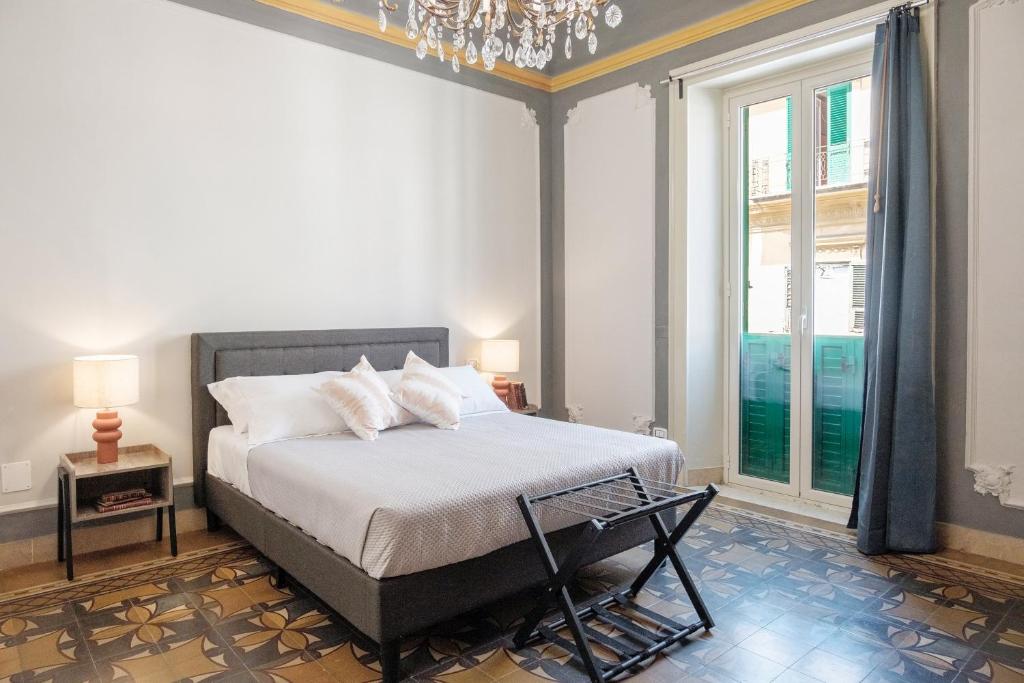 メッシーナにあるBorgo Antico Roomsのベッドとシャンデリアのある寝室