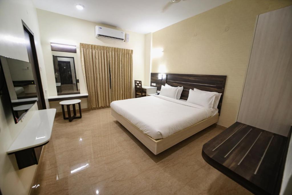 a hotel room with a bed and a bathroom at Avenue 11 Premium Stays Madurai in Madurai