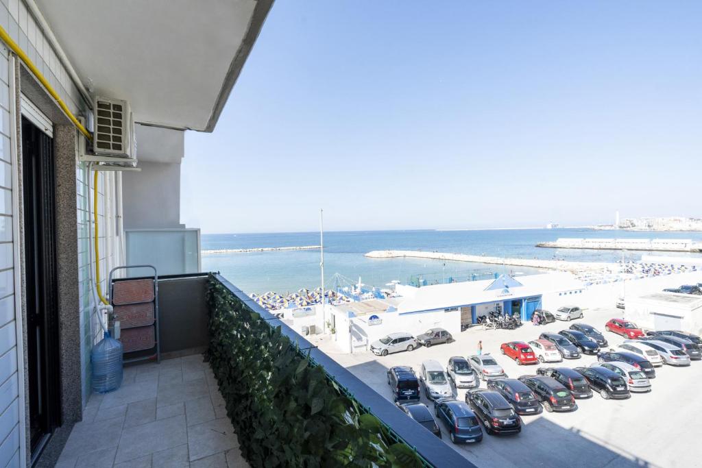 a group of cars parked in a parking lot next to a beach at Casa Lungomare IX Maggio by Wonderful Italy in Bari