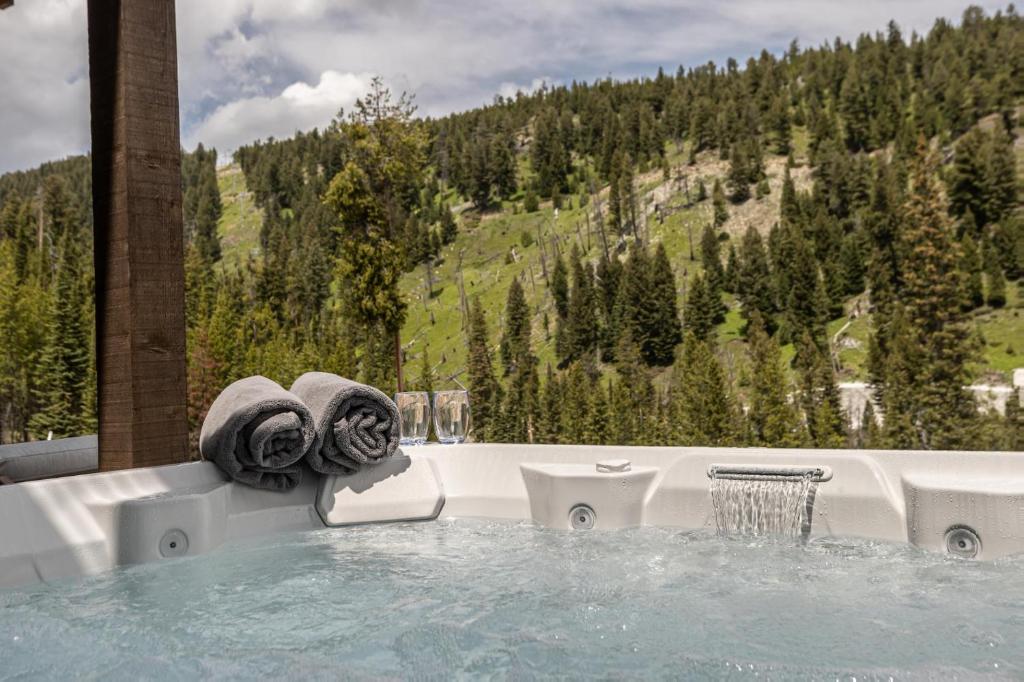 a jacuzzi tub with a view of a mountain at Spanish Peaks Highlands Cabin 59 in Big Sky