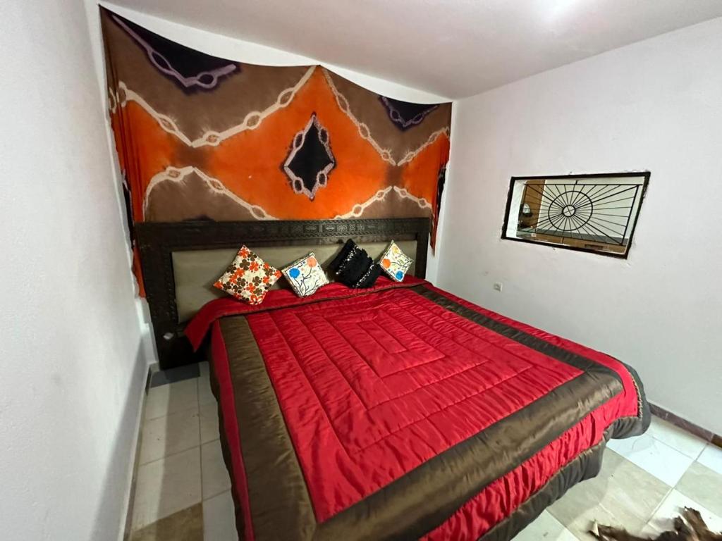 um quarto com uma cama com um edredão vermelho em Paradise 