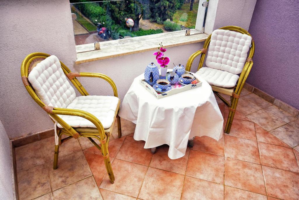 uma mesa com duas cadeiras e uma mesa com uma toalha de mesa branca em Apartments Link em Rovinj