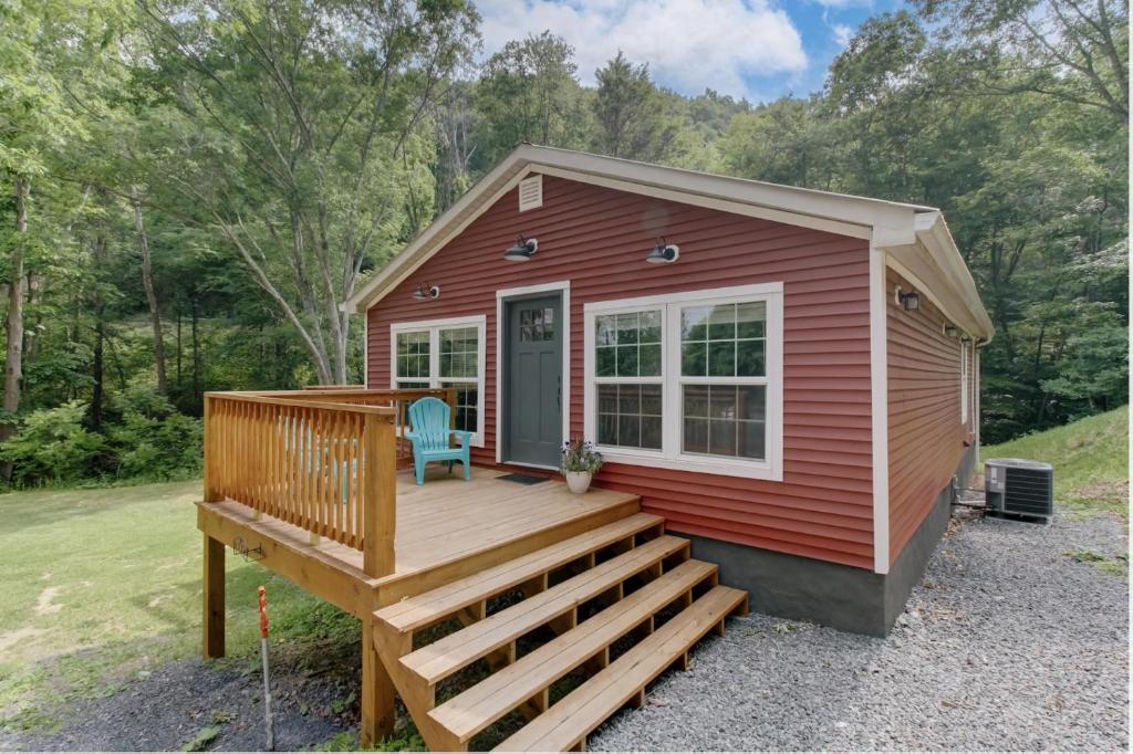 a red tiny house with a large deck at Creekside Cottage in Hot Springs
