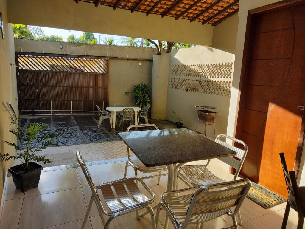 a patio with a table and chairs on a patio at Chalé Conforto de Casa in Barreirinhas