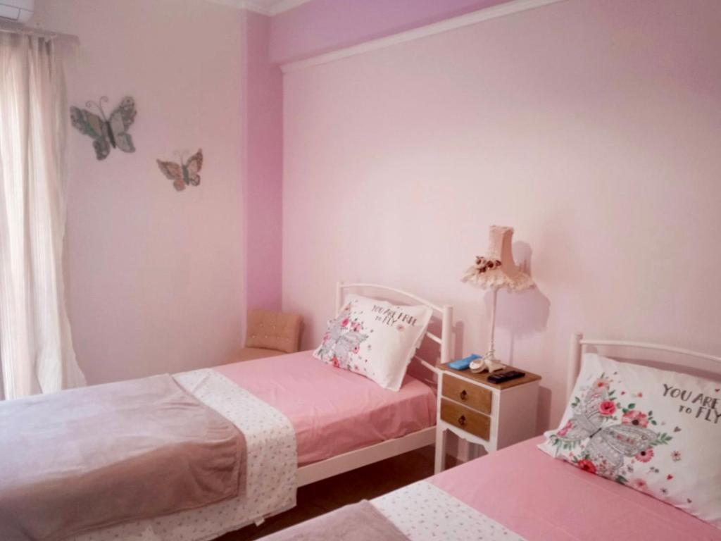 een slaapkamer met 2 bedden en vlinders aan de muur bij Nicole's home! in Nafpaktos