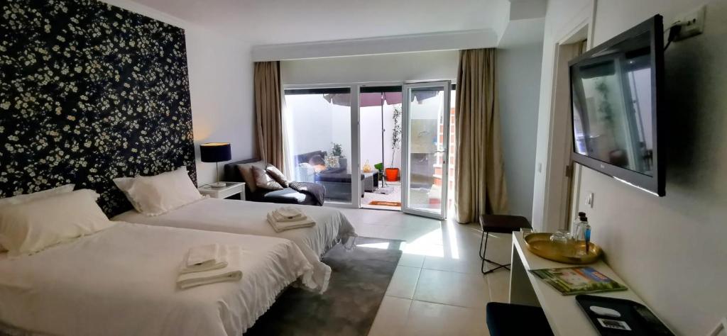 sypialnia z 2 łóżkami i salon w obiekcie Quarto Duplo com Kitchenette, WC e Pátio privativo w mieście Corroios