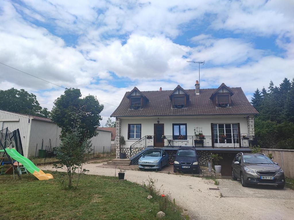 una casa con tres coches aparcados delante de ella en Aux portes de Chambord, en Muides-sur-Loire
