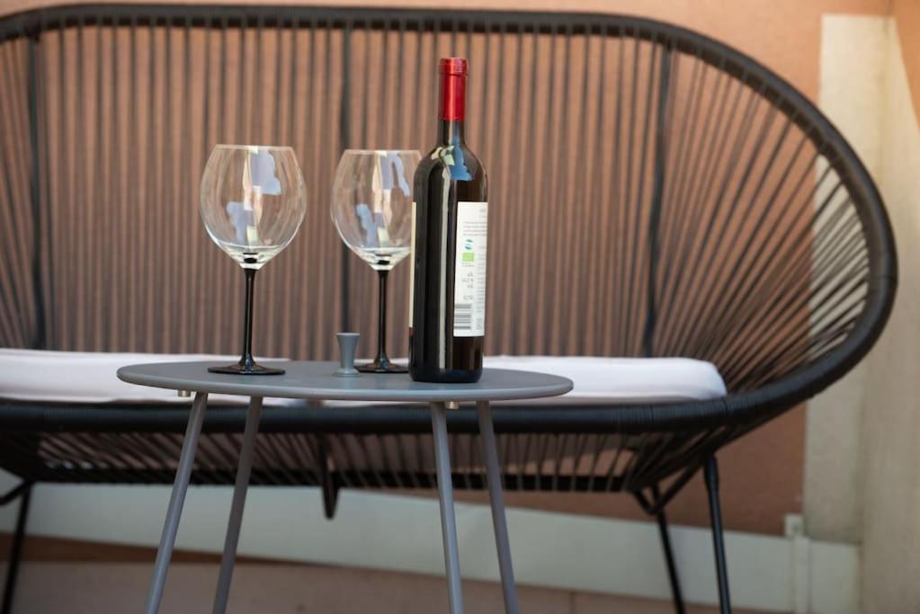 a bottle of wine sitting on a table with two wine glasses at Sun Hill Apartments Mlini in Mlini