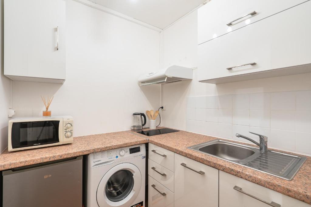 a kitchen with a sink and a microwave at Casa Lyon Cosy 1 Br Flat Part Dieu in Lyon