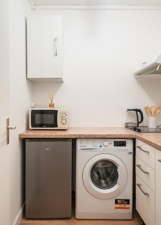 a kitchen with a washing machine and a microwave at Casa Lyon Cosy 1 Br Flat Part Dieu in Lyon
