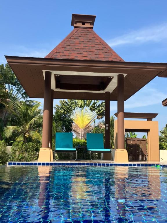 Kluai Mai Luxury Pool Villa, Panorama Resort في هوا هين: شرفة بجانب المسبح في منتجع