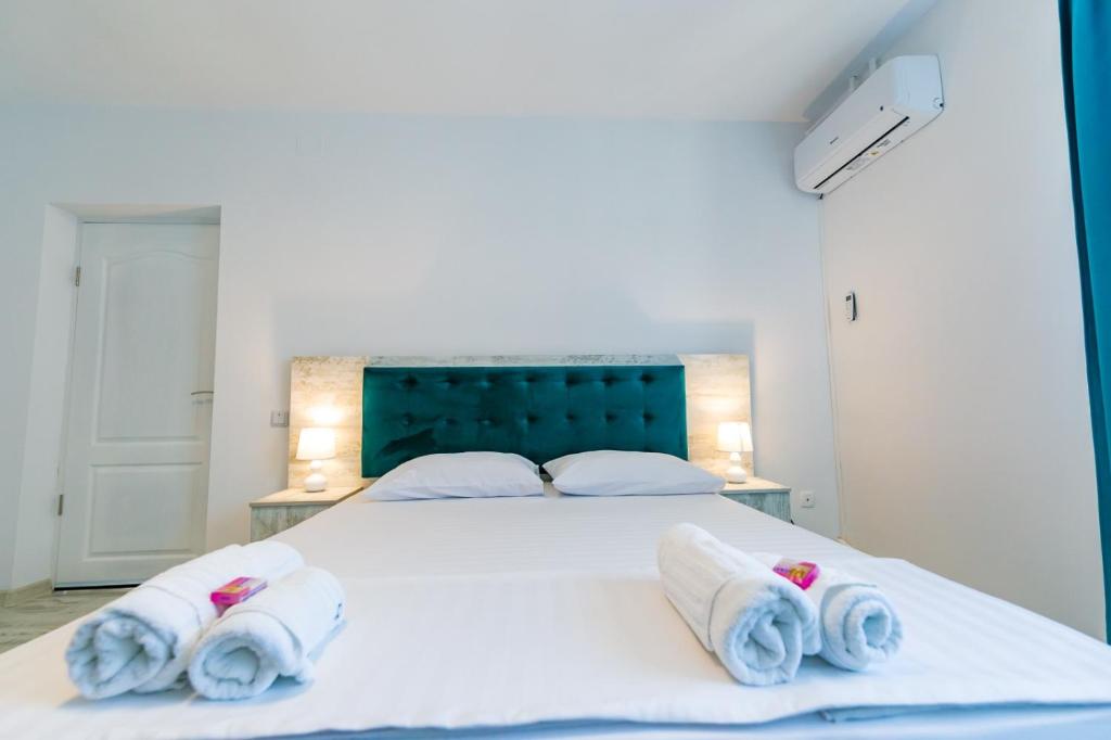 - une chambre avec un grand lit blanc et des serviettes dans l'établissement Casa Andrei & Alex 2 Mai, à 2 Mai