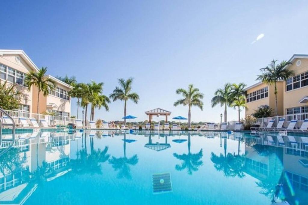 a swimming pool at a resort with palm trees at Beach Condo in Clearwater Beach