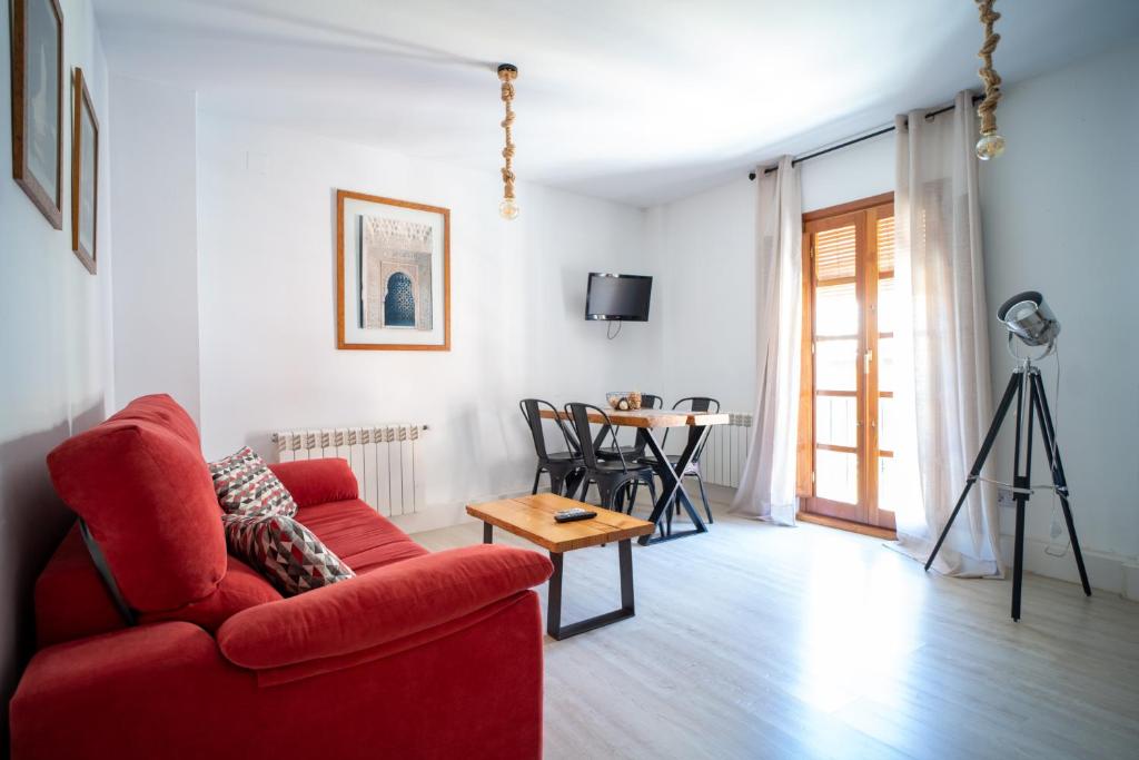 - un salon avec un canapé rouge et une table dans l'établissement Precioso apartamento al lado de la Alhambra, à Grenade