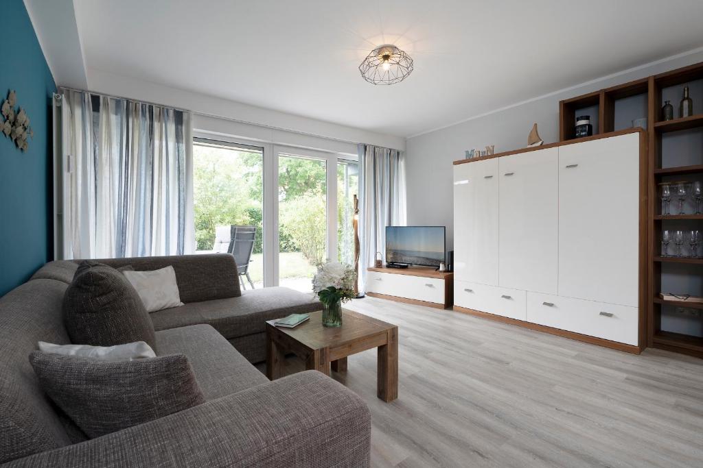 ein Wohnzimmer mit einem Sofa und einem TV in der Unterkunft Waldstraße 8 Wohnung 1 in Kellenhusen