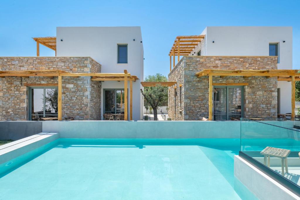 a swimming pool in front of a house at Azzure Luxury Suites in Potos