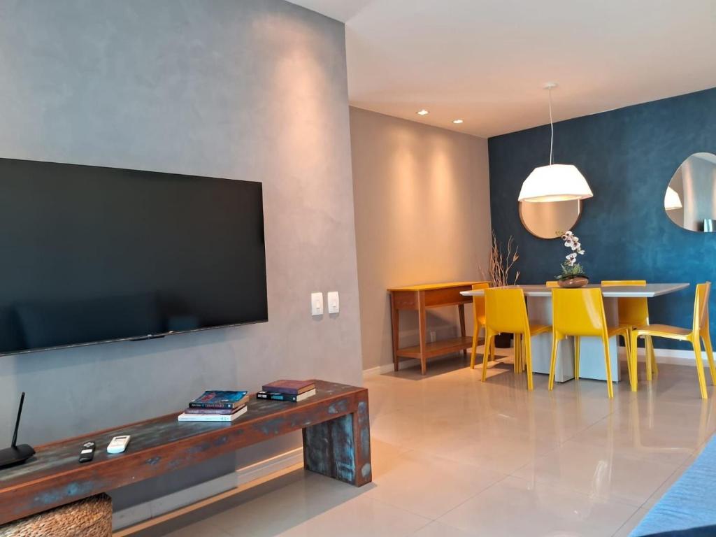 a living room with a flat screen tv and yellow chairs at Cabo Frio com conforto e estilo!!! in Cabo Frio