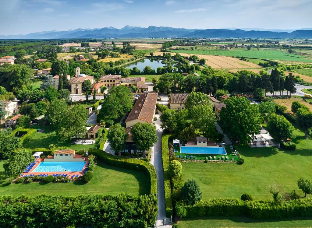 una vista aerea di una casa con piscina e lago di Fattoria di Migliarino a Migliarino