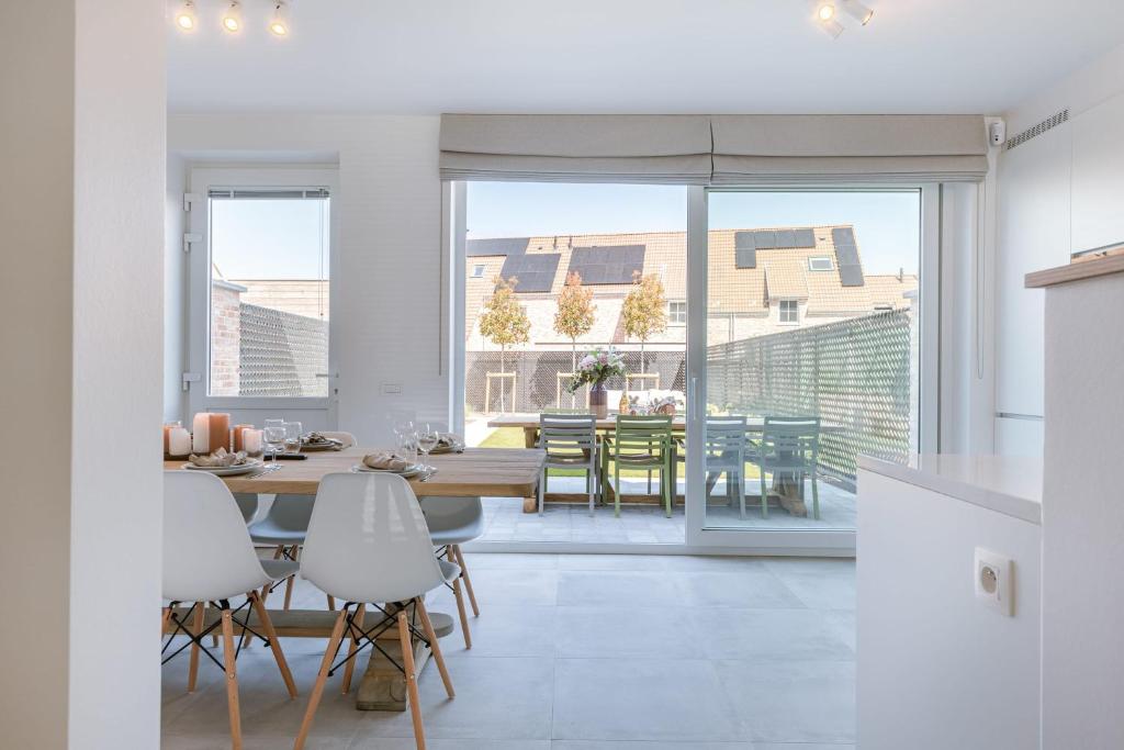 cocina y comedor con mesa y sillas en Modern house JULIE with spacious garden and garage, en Middelkerke