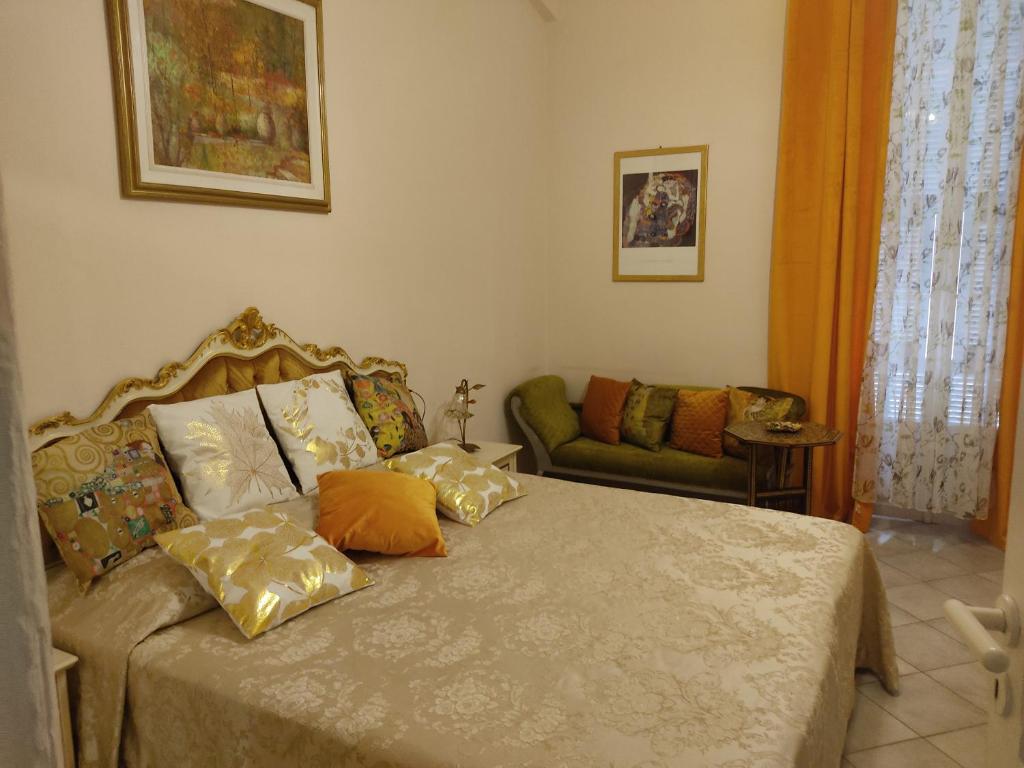 a bedroom with a bed with pillows and a couch at Hotel Sanremo in Sanremo