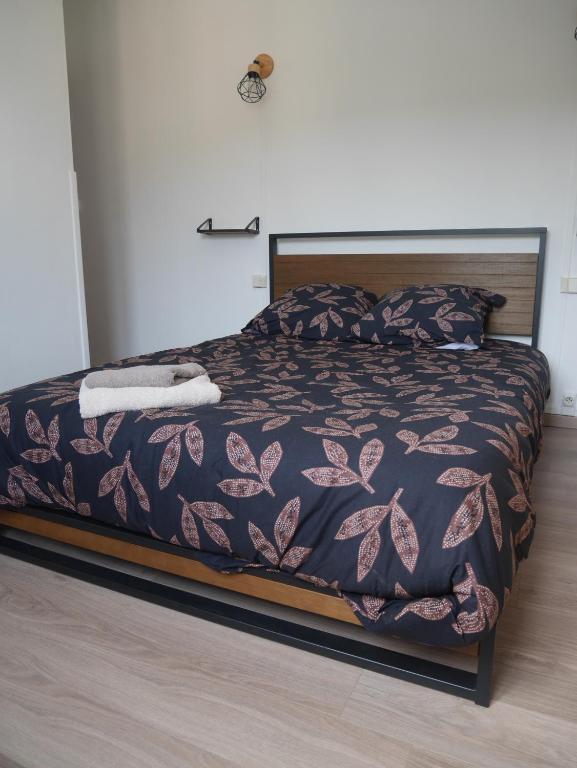 een slaapkamer met een bed met een paars dekbed bij Le Laurenti in Quérigut