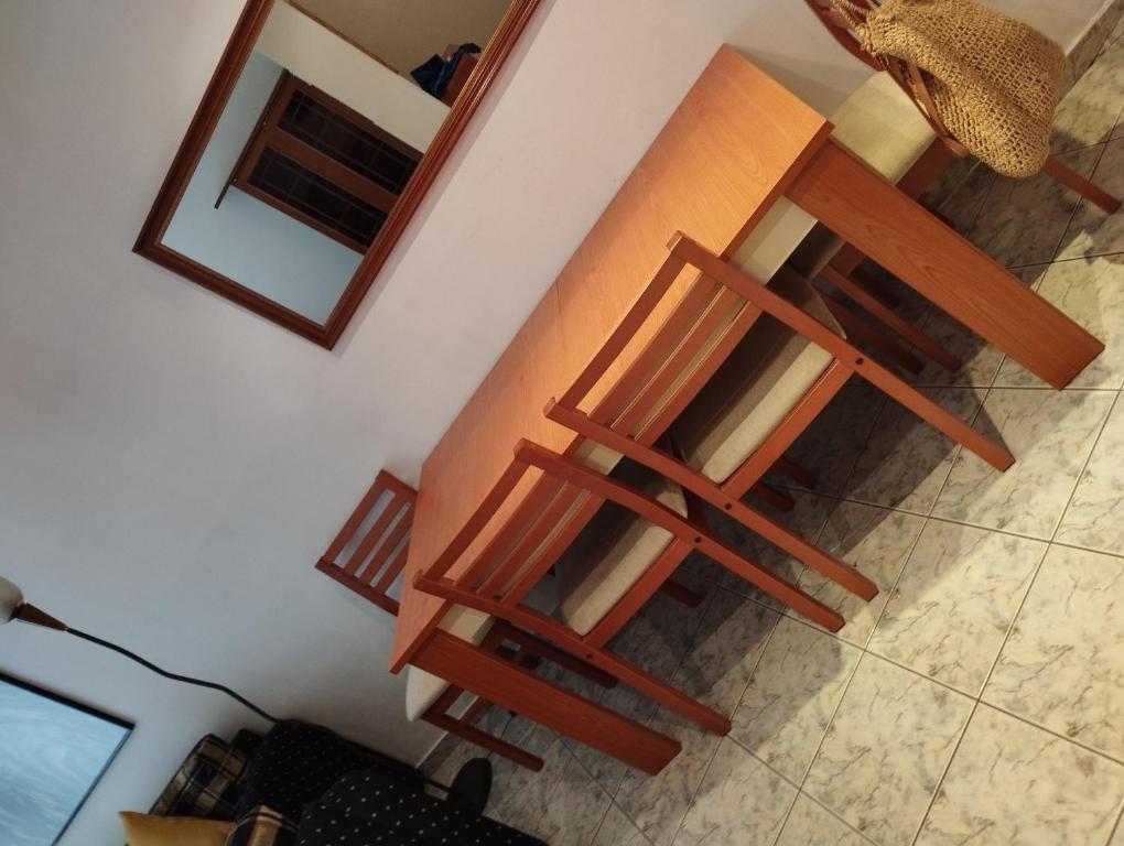 2 sillas de madera sentadas en el suelo en una habitación en PERIGIALI APARTMENT, en Kavala