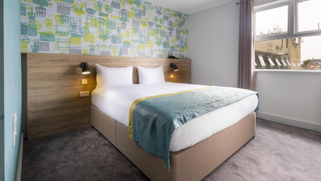 1 dormitorio con cama y ventana en The Camden Street Hotel, en Dublín
