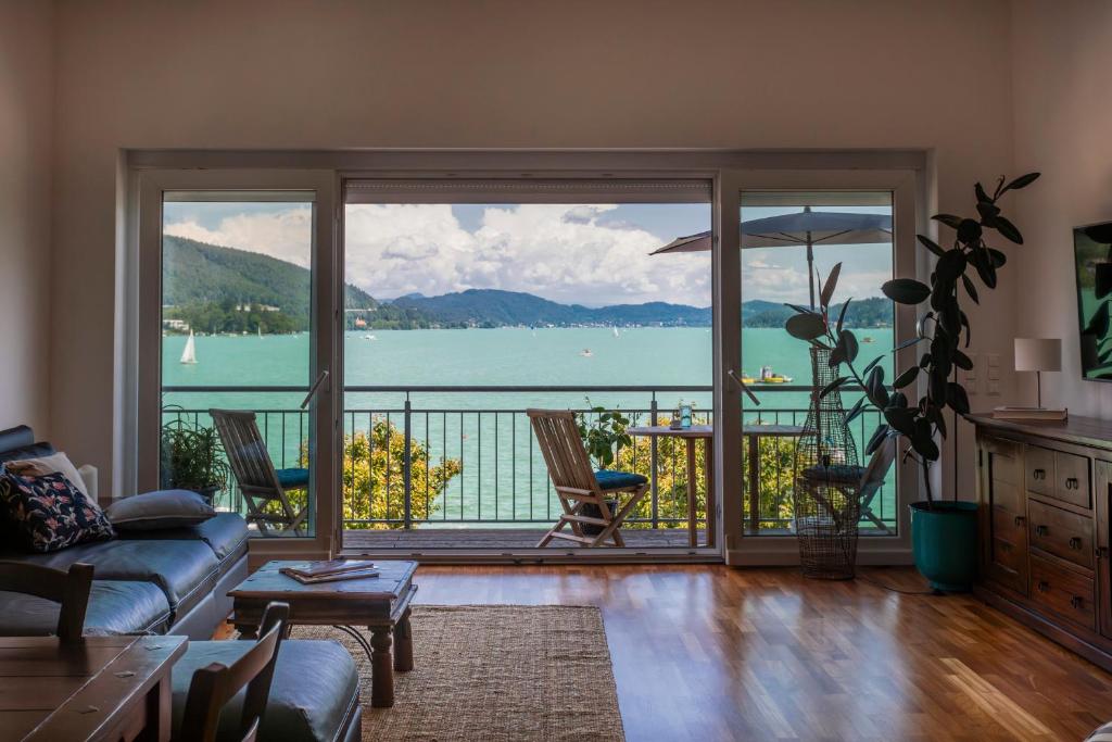 uma sala de estar com vista para a água em Seeapartment Da Leopoldo II em Velden am Wörthersee