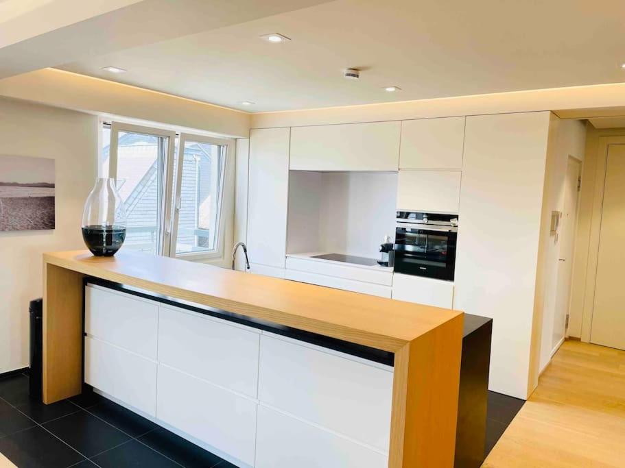 a kitchen with white cabinets and a counter top at Luxurious 1 bedroom in the Heart of City Center - 25 in Luxembourg